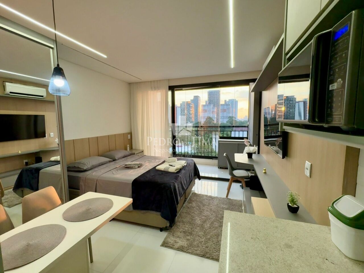 Interior de apartamento studio compacto de 30 metros quadrados em Sao Paulo, com sala, cozinha e area de dormir integradas